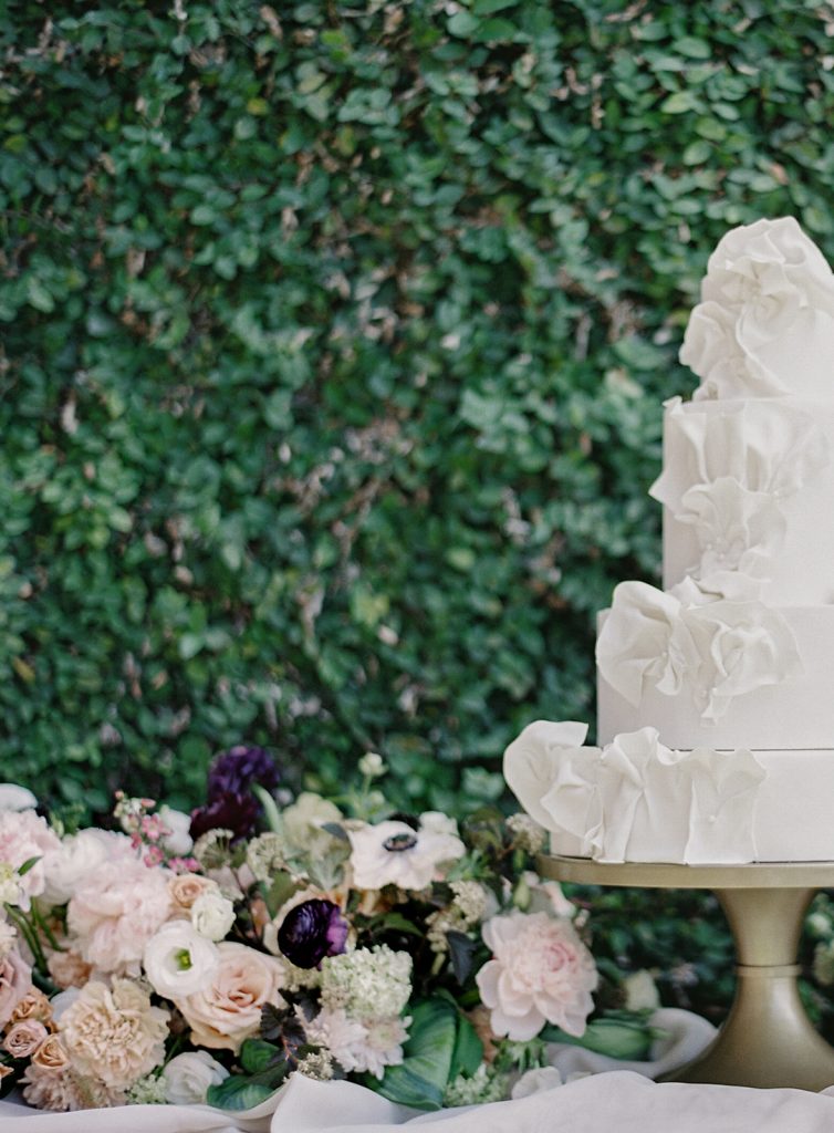 White four tiered wedding cake with icing made ruffles going up the side. Photographed at Middleton Place by wedding photographers in Charleston Amy Mulder Photography.
