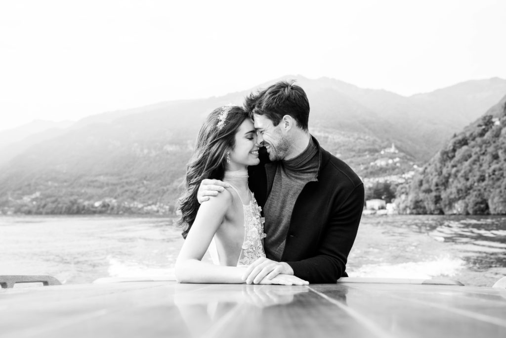 Black and white photograph of couple on a boat on Lake Como, Italy. Photographed by Italy wedding photographer, Amy Mulder Photography.