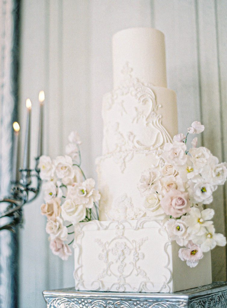 Four tiered wedding cake with intricate detailing for luxury wedding at Villa Sola Cabiati on Lake Como, Italy. Bride and groom inside Villa Sola Cabiati on Lake Como, Italy. Photographed by Italy wedding photographer, Amy Mulder Photography.