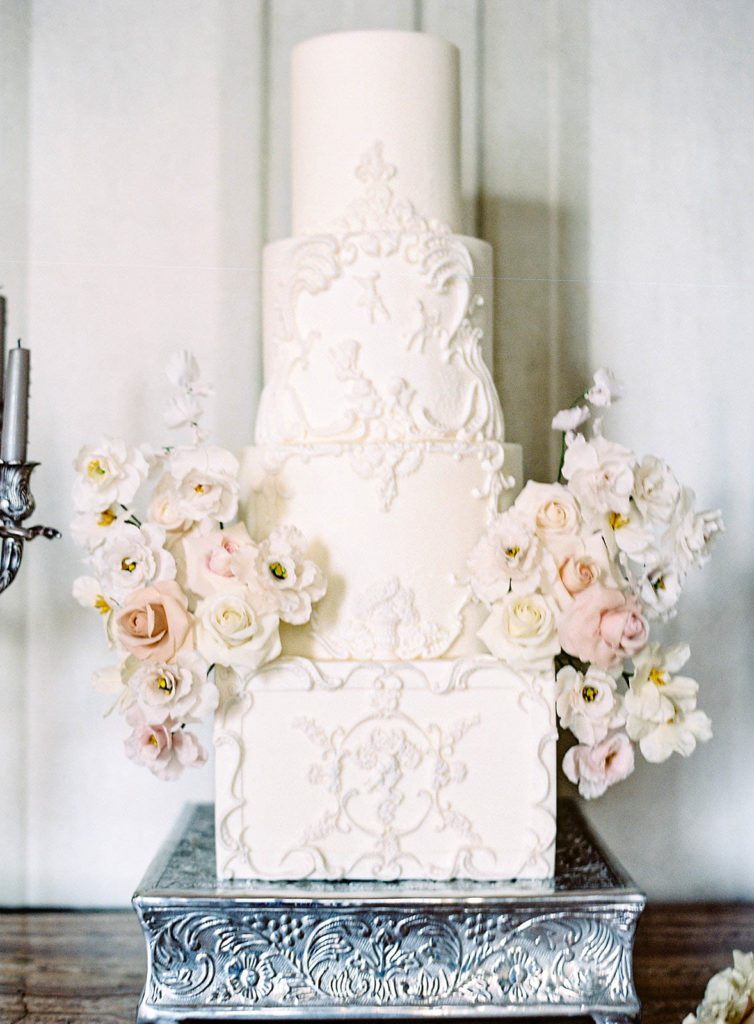 Four tiered wedding cake with stucco design for a Villa Sola Cabiati on Lake Como in Italy photographed on film by Lake Como wedding photographer.