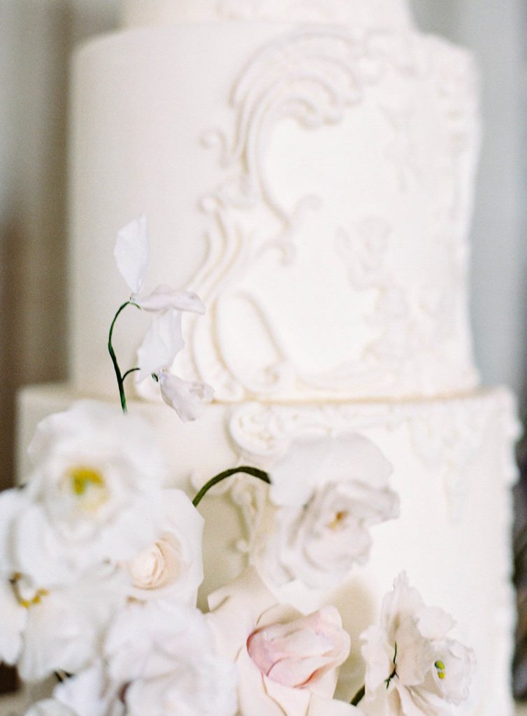 Four tiered wedding cake with stucco design for a Villa Sola Cabiati on Lake Como in Italy photographed on film by Lake Como wedding photographer.