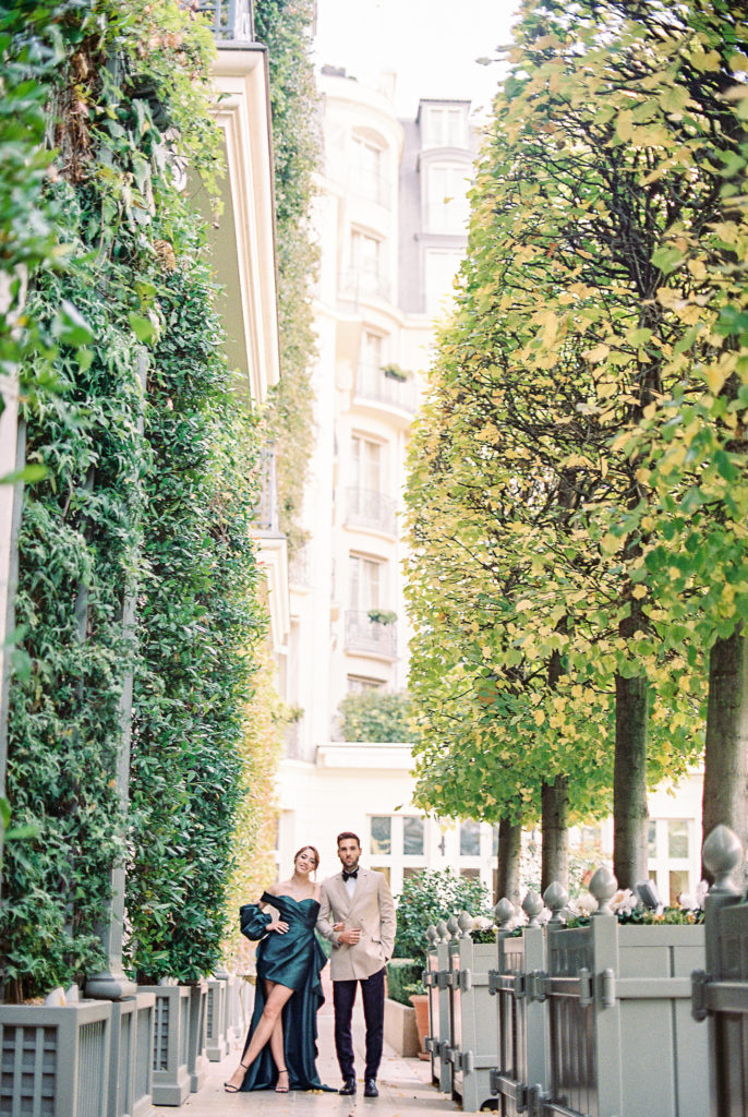 Bride in emerald green gown and groom in peach dinner jacket for their cocktail hour at their wedding at the Ritz Paris.