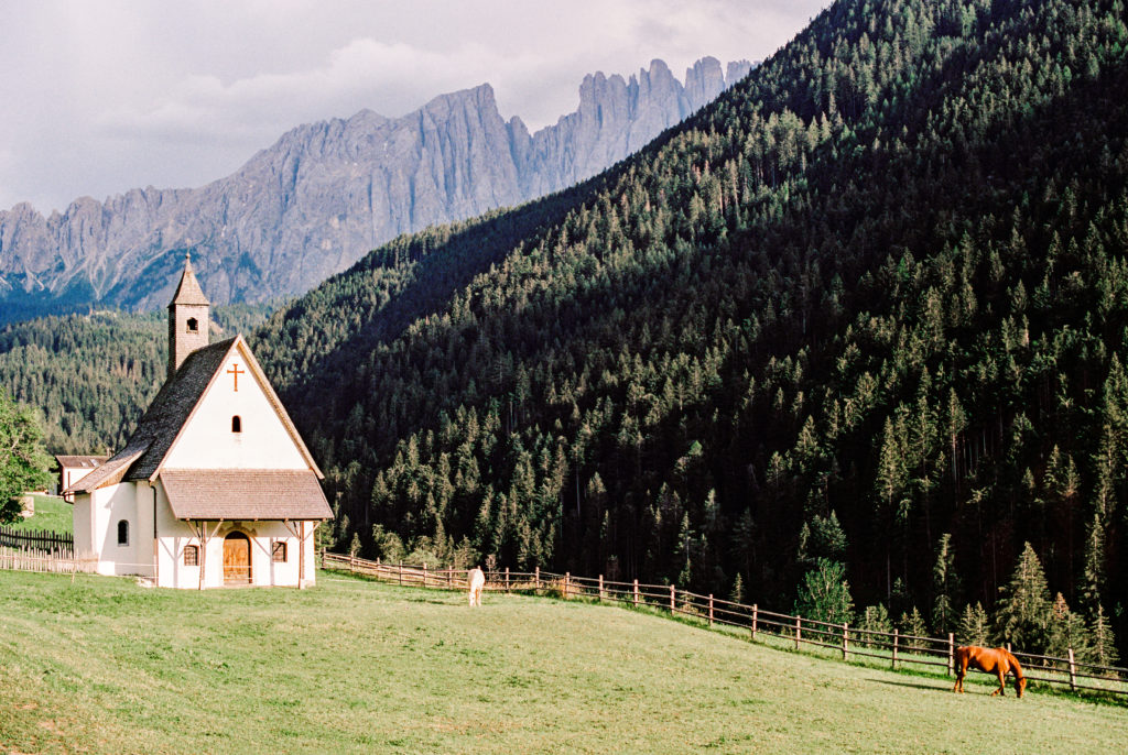 Chapel in the meadow surrounded by the Dolomite mountains.