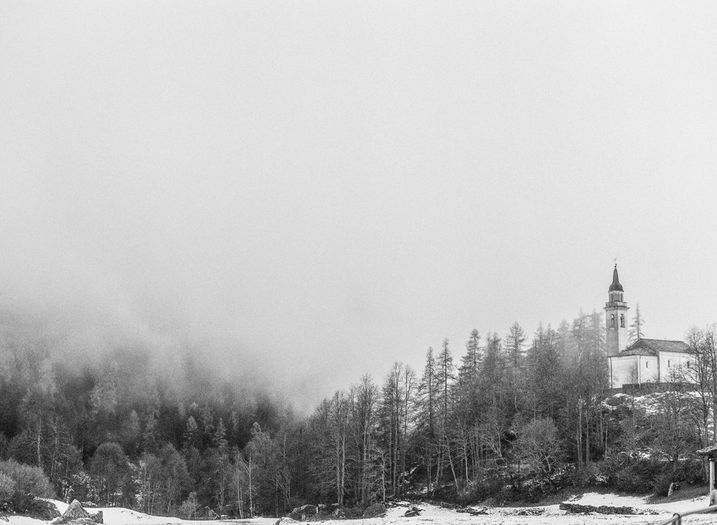 A church in the Alps with fog surrounding it in Switzerland