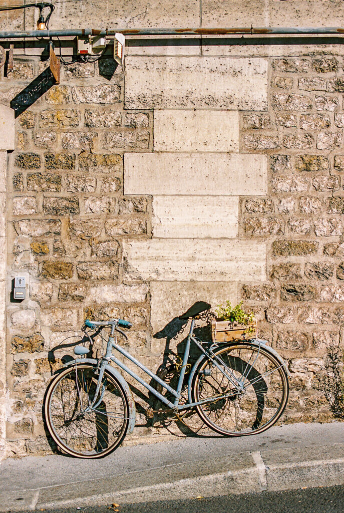 Paris street with blue bicycle leaning against the stone 