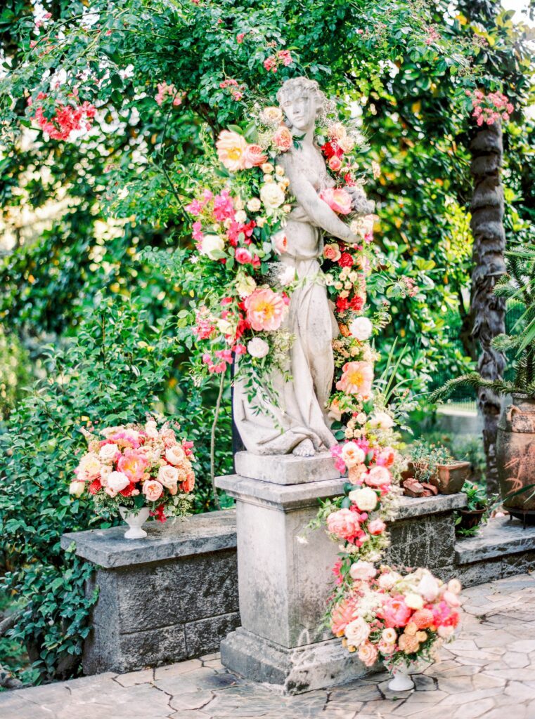 Floral installation surrounding statue for a Lake Como wedding in Italy photographed on film by Lake Como wedding photographer