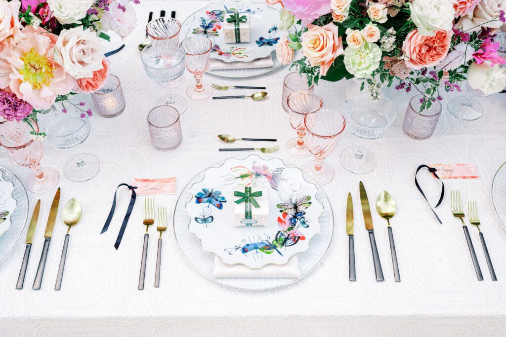 Colorful butterfly patterned table settings with pink glasses for a Lake Como wedding in Italy photographed on film by Lake Como wedding photographer