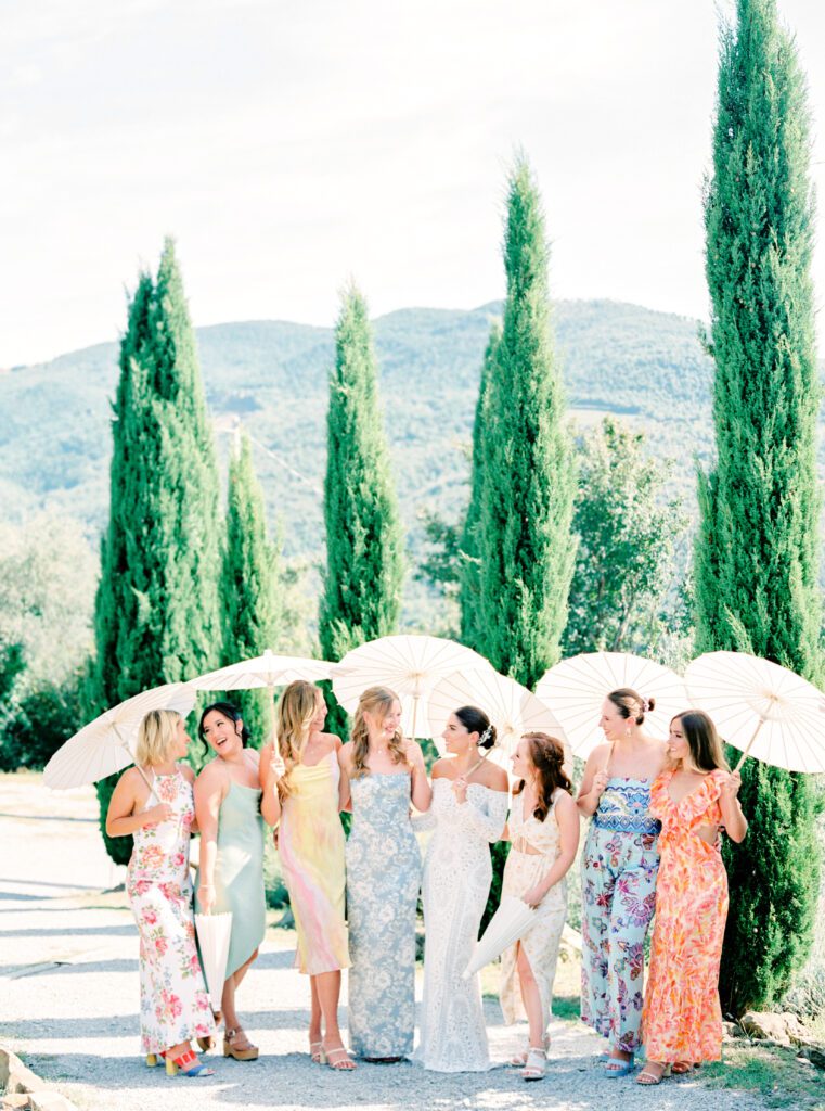 Bridesmaids with parasols at Tuscany Wedding in the olive grove at Villa Montanare near Cortona, Italy photographed by Italy wedding photographer 