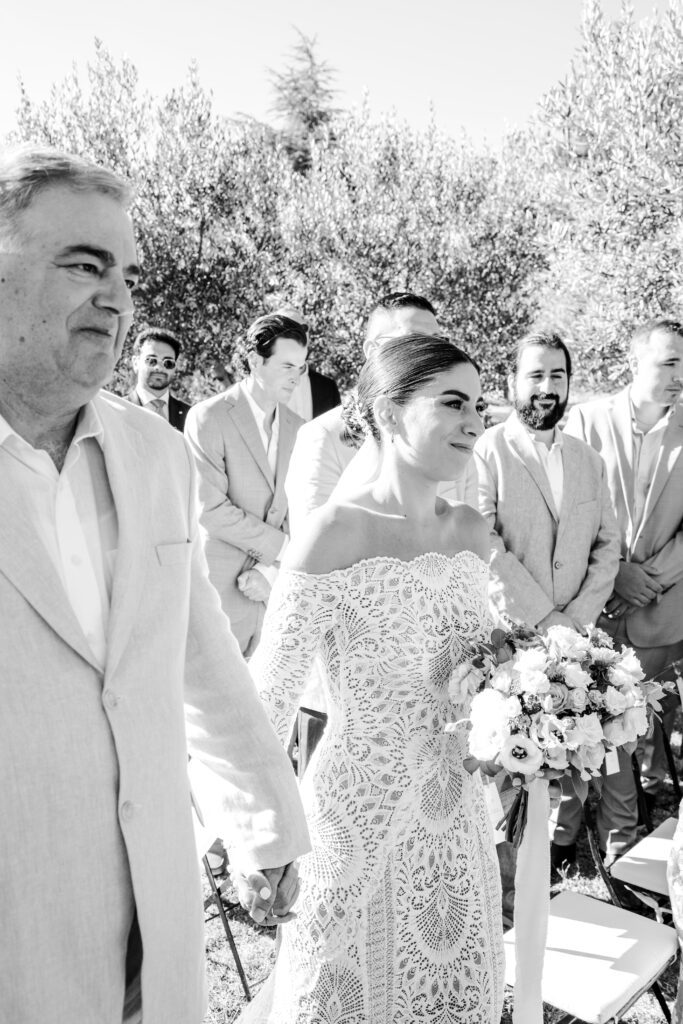 Father and bride walking down the aisle at Tuscany Wedding ceremony in the olive grove at Villa Montanare near Cortona, Italy photographed by Italy wedding photographer 