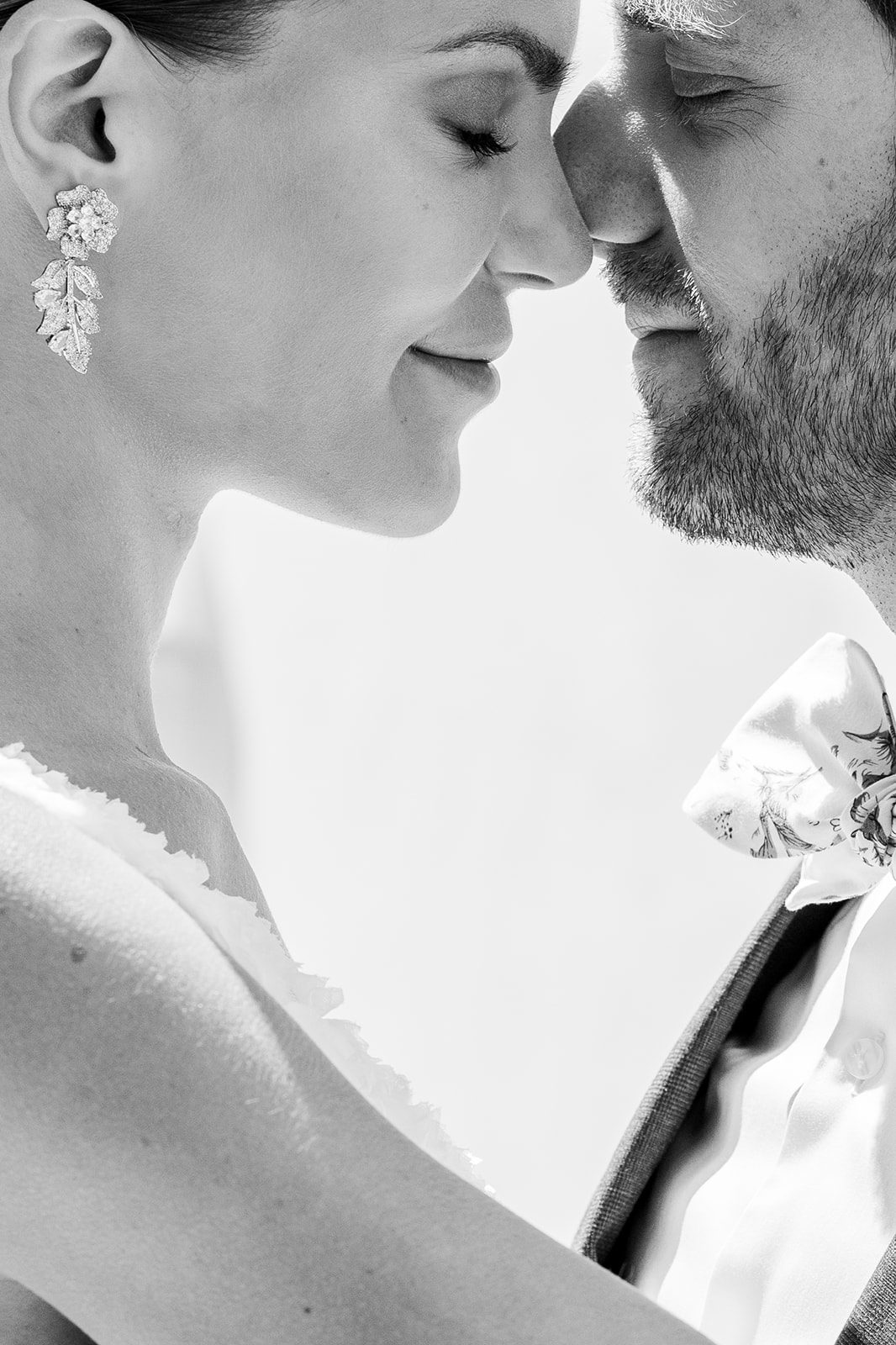 Black and white film photograph of couple in an intimate moment with their noses resting against each others and eye closed photographed during a Paris engagement session by Italy wedding photographer