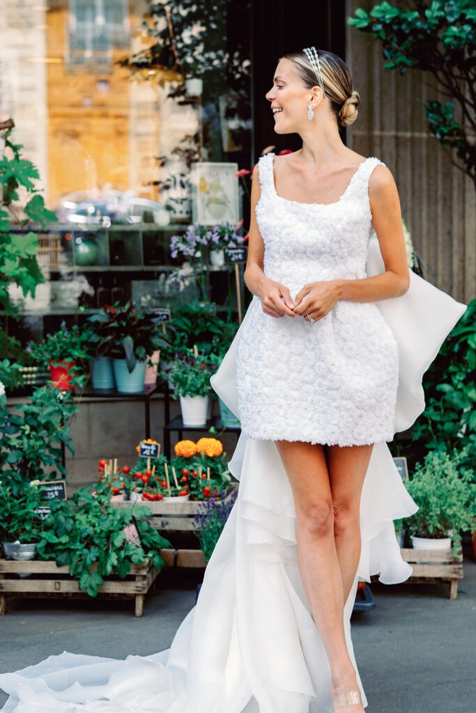 Paris engagement session with bride in a short 3d floral patterned sleeveless dress with a large oversized bow in the back with a train photographed on film by Italy wedding photographer