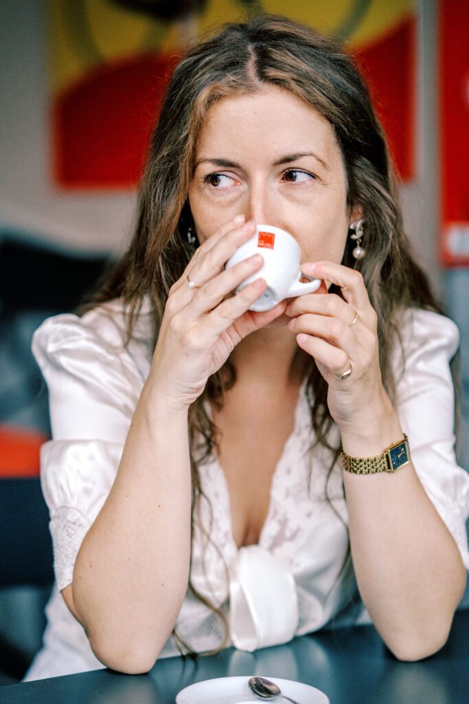 Lake Como vacation session in Argegno at cafe enjoying espresso, laughing and holding hand photographed by Lake Como photographer